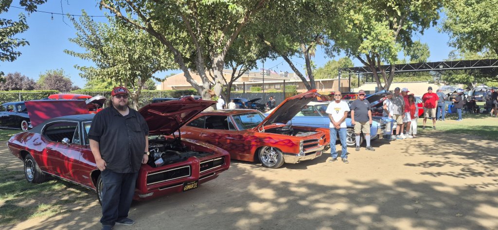 Club members standing with their Pontiacs, led by a red 1968 GTO, at the 2026 Valley Nationals